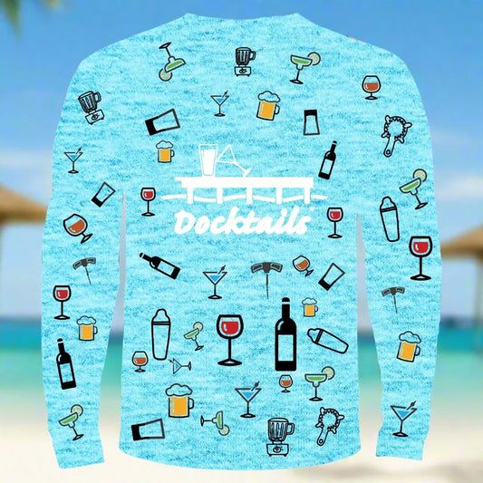 A light blue heather long-sleeve shirt with a 'Docktails' graphic and cocktail-themed illustrations, shown against a blurred beach background.