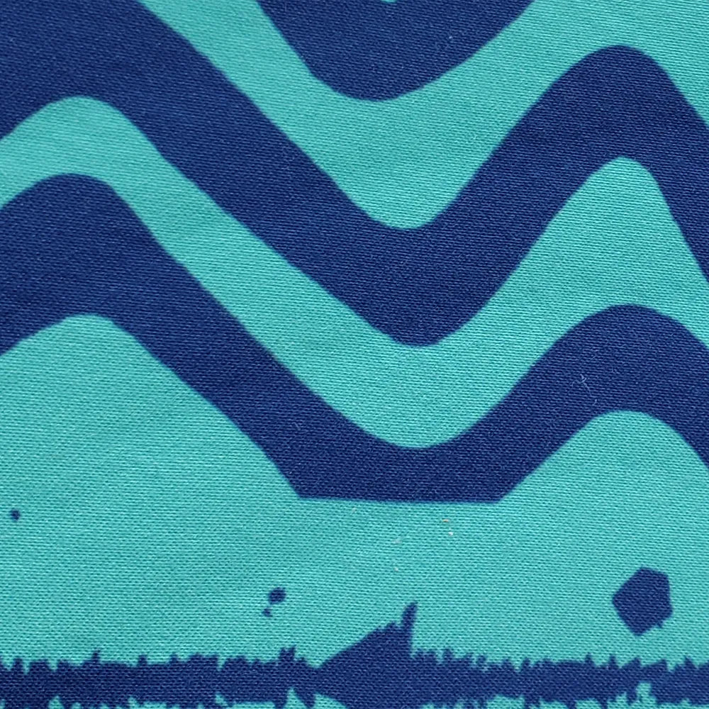 A close-up of a fabric pattern featuring bold, wavy horizontal stripes in deep navy blue and bright turquoise, with a distressed dark navy border at the bottom.