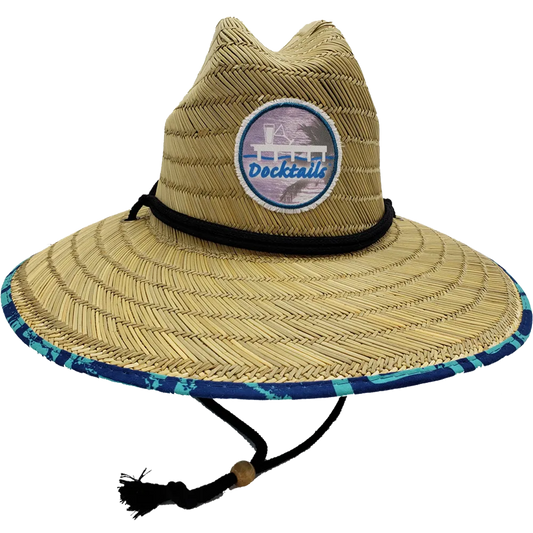 Wide brim lifeguard hat with thin brown fabric band and chin strap with a wooden bead. Edge of brim has turquoise and navy fabric. Crown has a Docktails logo patch.