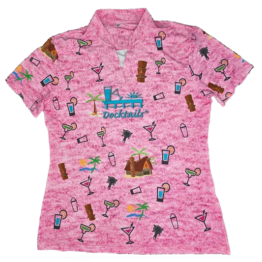 A women's short-sleeve collared polo shirt in a heathered pink fabric, featuring an all-over tropical cocktail and beach-themed print with a central 'Docktails' logo.